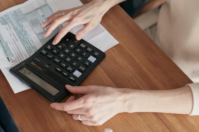 Person looking at a calculator with papers next to them